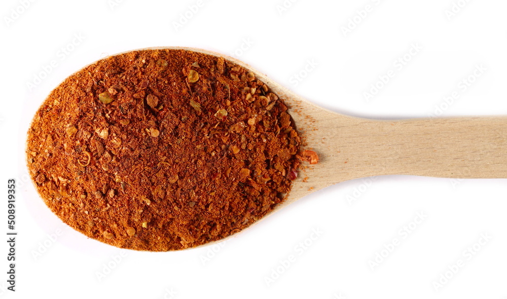 Spicy chili pepper flakes, crushed, milled red paprika pile in wooden spoon isolated on white, top view Spicy chili pepper flakes, crushed, milled red paprika pile in wooden spoon isolated on white, top view