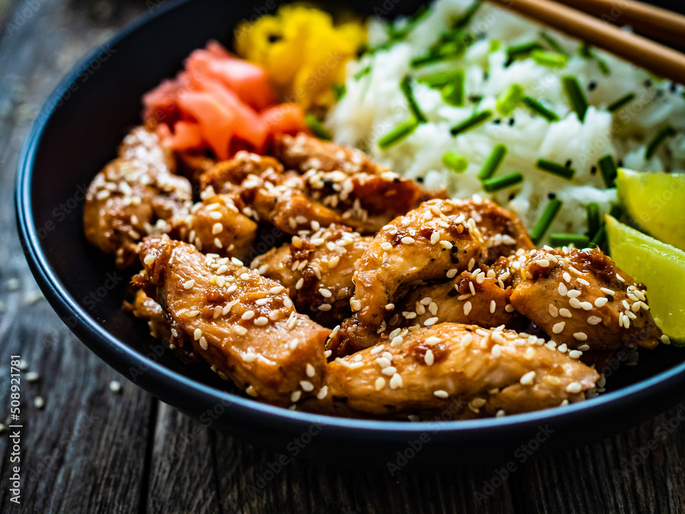 Teriyaki chicken nuggets with rice and vegetables on wooden table
Teriyaki chicken nuggets with rice and vegetables on wooden table
