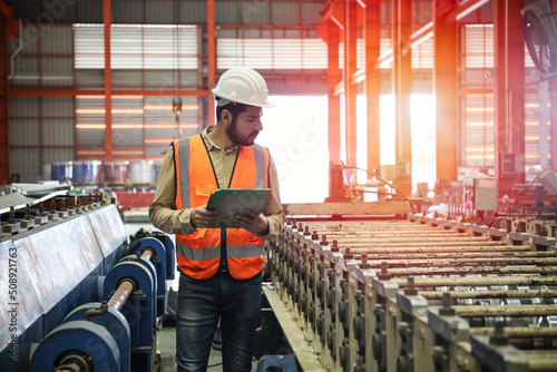 The engineer smart posing in production line process after check and inspection the machine in factory, professional technician operating or work in manufacturing industrial