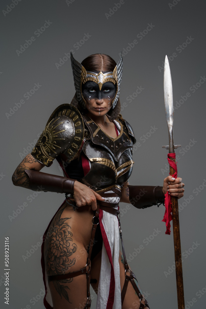 Obraz premium Portrait of ancient amazon with spear dressed in armour staring at camera.