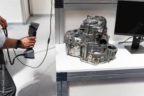 Engineer scans the detail with 3D scanner for reverse engineering photo