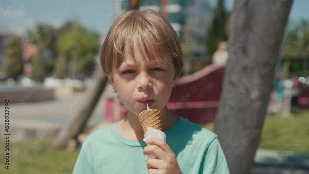 Kid eats ice-cream. Young boy child eating icecream dessert. High quality 4k footage Kid eats ice-cream. Young boy child eating icecream dessert. High quality 4k footage