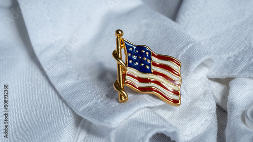 US flag metal badge on the lapel of a white shirt