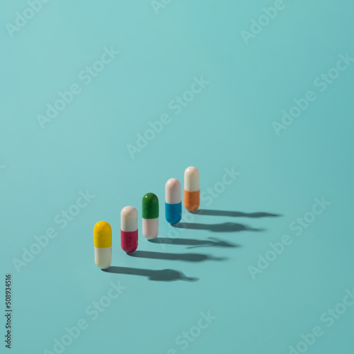 Medicine pills with colorful elements and human shadows on the surface. Health  drugs addiction conceptual background.