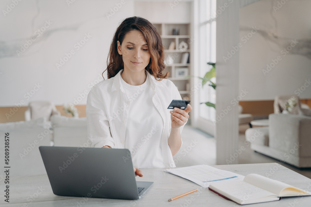 Young pretty woman is going to buy through internet. European girl is holding credit card. Young pretty woman is going to buy through internet. European girl is holding credit card.