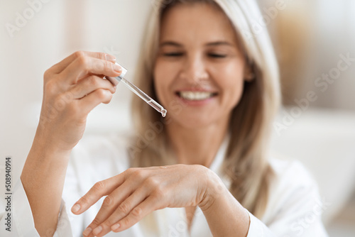 Cheerful blonde lady testing brand new beauty product