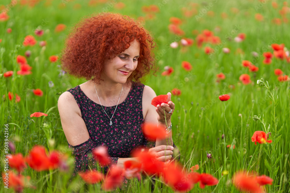 Redhead woman in a poppy field Redhead woman in a poppy field