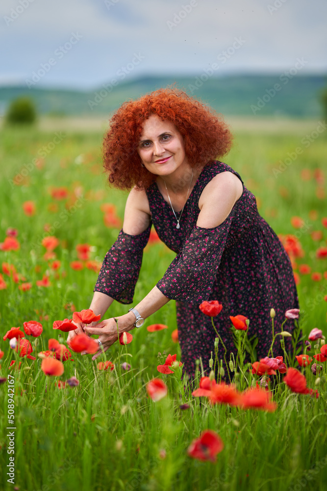 Redhead woman in a poppy field Redhead woman in a poppy field
