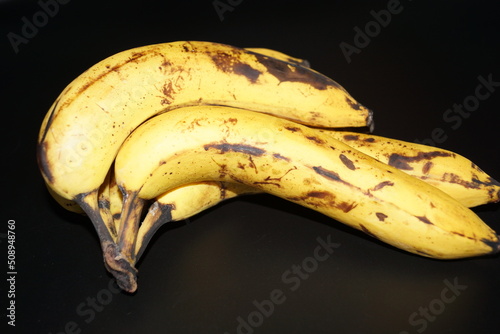 Bananen im reifen und überreifen zustand mit blauen und schwarzen Hintergrund