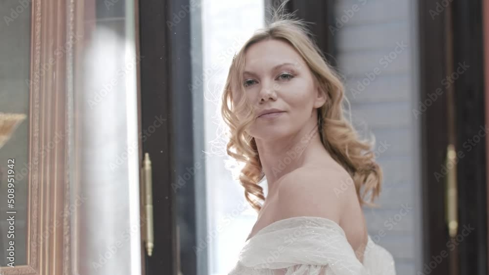 Beautiful bride with styled blonde hair turns over her shoulder and smiles Beautiful bride with styled blonde hair turns over her shoulder and smiles