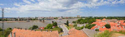 Cityscape of Novi Sad, bridge over Danube river. Panoramic view. Downtown at riverside. Cloudy spring day at noon. Serbia. Europe.
