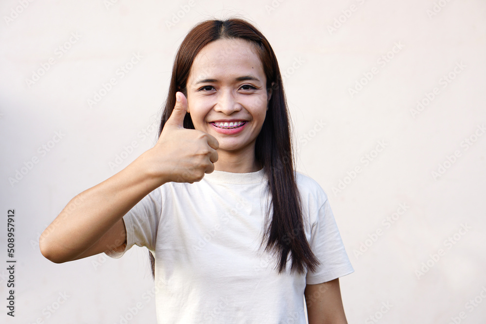 Asian woman smiling happily Raise your hand as a sign of ok. Asian woman smiling happily Raise your hand as a sign of ok.