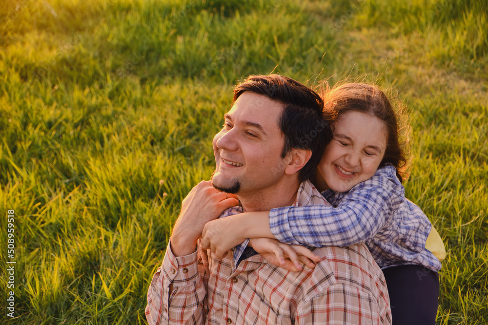 Smiling little girl hugging her father outside Smiling little girl hugging her father outside