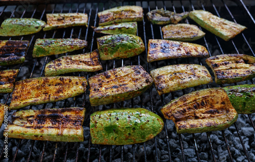 Zucchini on the grill. Grilled chopped vegetable. Fire-fried food. Vegetarian food. Delicious marinated food. Healthy picnic snack