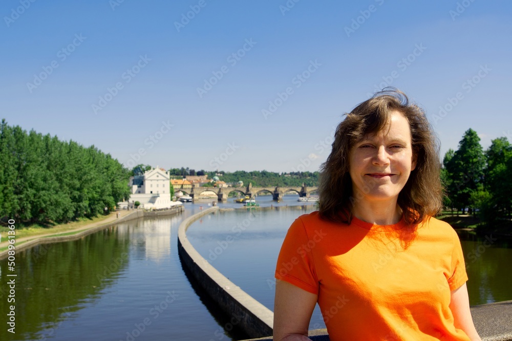 Woman on the Legi bridge, with the Charles Bridge behind her.