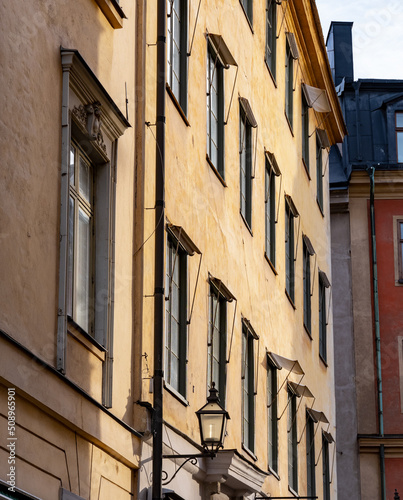 Facade of historic building with yellow stone and old street lamp. Shot in Stockholm, Sweden