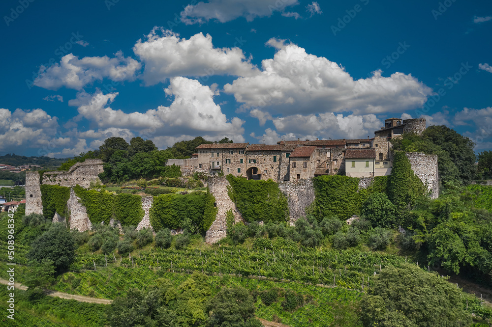 Drone view, Pozzolengo Castle panorama, Italy. Top view of Pozzolengo Castle with cumulus clouds in the background. Historic castle on a hill in Italy.