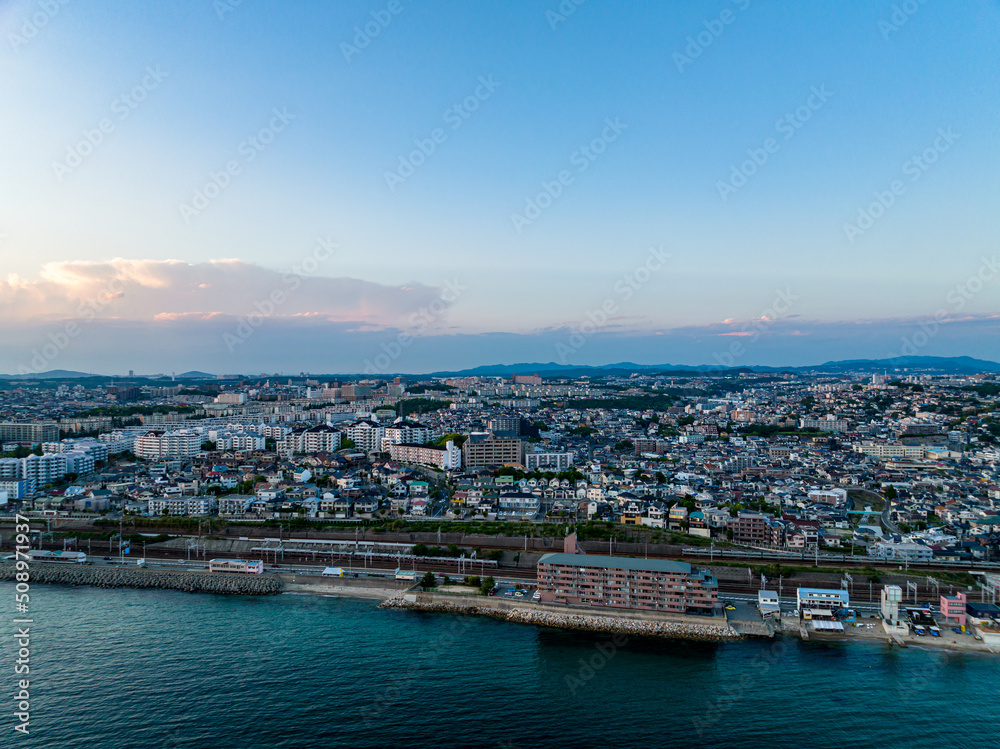 Aerial view of waterfront apartment and sprawling coastal development after sunset
