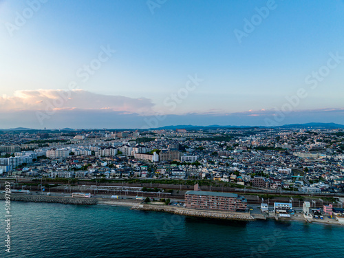Aerial view of waterfront apartment and sprawling coastal development after sunset