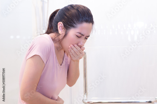 Asian Beautiful woman vomit caused by food poisoning or stress or pregnant