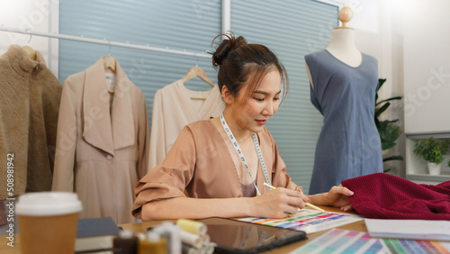 Fashion design concept, Asian female fashion designer choosing color for new clothes collection