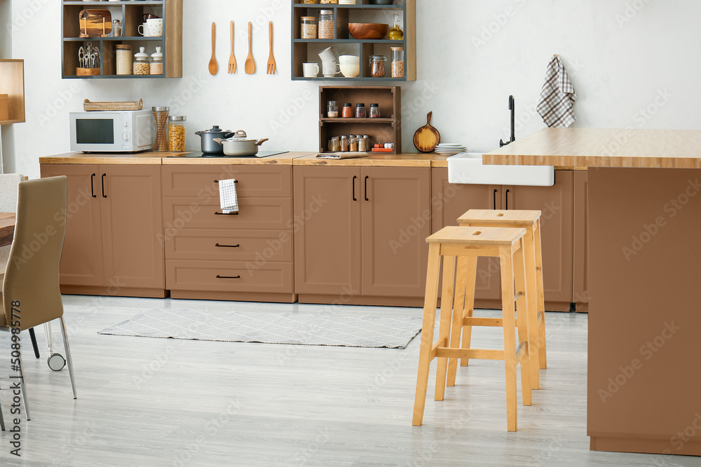 Interior of light modern kitchen with brown furniture Interior of light modern kitchen with brown furniture