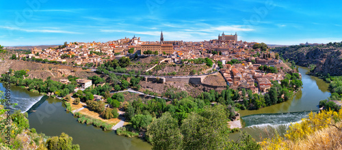 Picturesque panorama of the ancient city of Toledo on the banks of the Tagus River on a sunny afternoon against the blue sky. Capital of the province of Toledo, community of Castilla–La Mancha, Spain