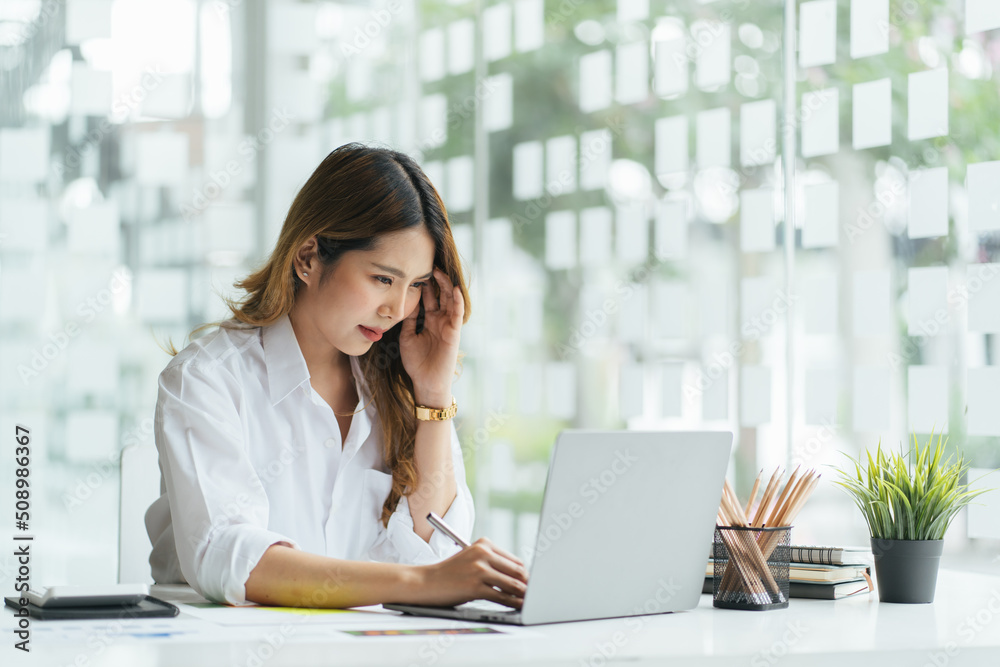 Tired asian business woman with headache at office, feeling sick at work, Portrait of tired young business woman with laptop computer. Tired asian business woman with headache at office, feeling sick at work, Portrait of tired young business woman with laptop computer.