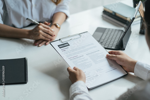 Close up view of job interview in office, focus on resume writing tips, employer reviewing good cv of prepared skilled applicant, recruiter considering application, hr manager making hiring decision