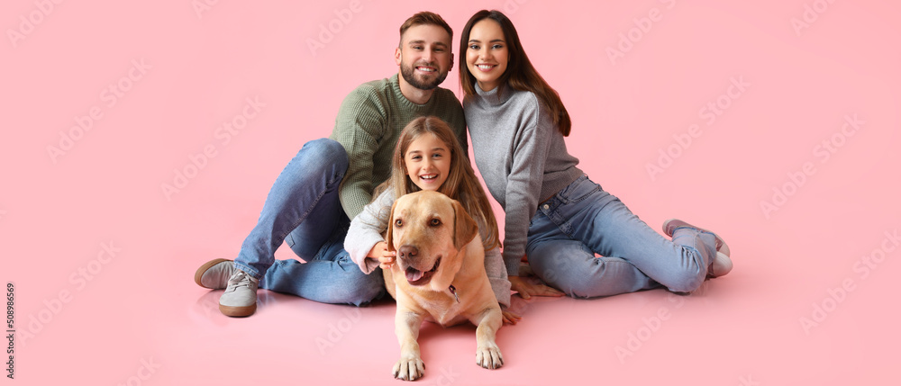 Happy family with cute Labrador dog on pink background