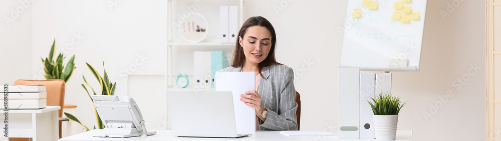 Pretty secretary with documents sitting at table in office Pretty secretary with documents sitting at table in office