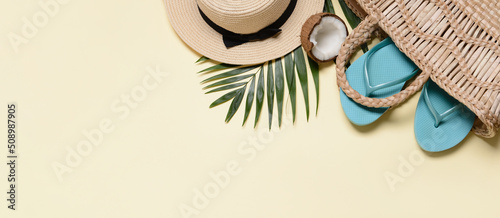 Beach bag, hat coconut and tropical leaf on light color background with space for text