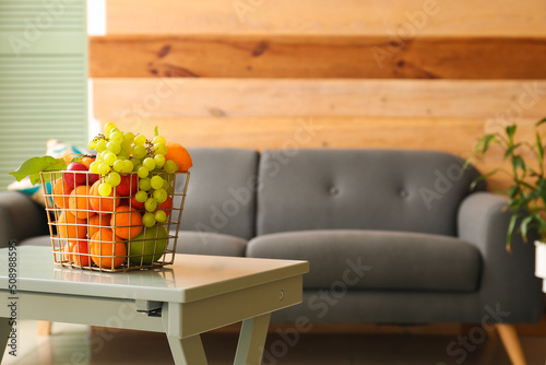 Fototapeta Naklejka Na Ścianę i Meble -  Fruit basket on table near sofa in stylish living room