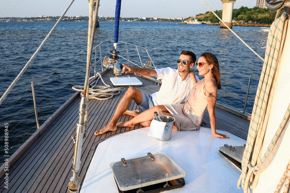 Happy young couple resting on yacht