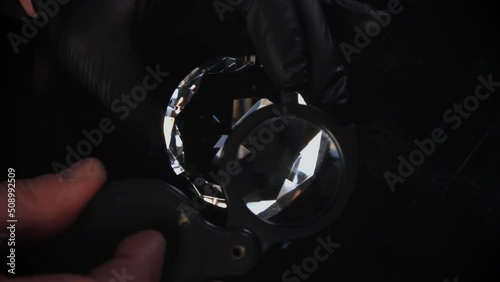 Appraiser checks clear diamond, closeup it's texture and refraction. Style and fashion undustry photo