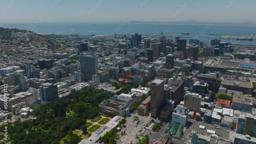 Fly above buildings in large city at seaside. Multistorey houses in city centre. Cape Town, South Africa Fly above buildings in large city at seaside. Multistorey houses in city centre. Cape Town, South Africa
