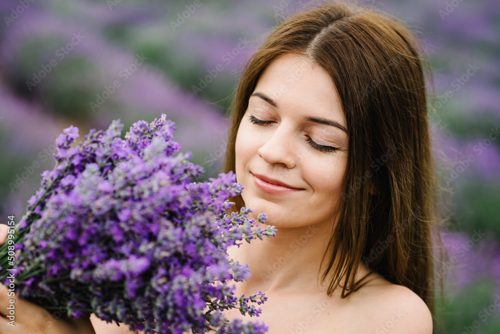 Beautiful girl in a dress in purple lavender field. Woman walking on the lavender field. Female collects lavender. Enjoy the floral glade, and summer nature. Natural cosmetics and eco makeup concept. Beautiful girl in a dress in purple lavender field. Woman walking on the lavender field. Female collects lavender. Enjoy the floral glade, and summer nature. Natural cosmetics and eco makeup concept.