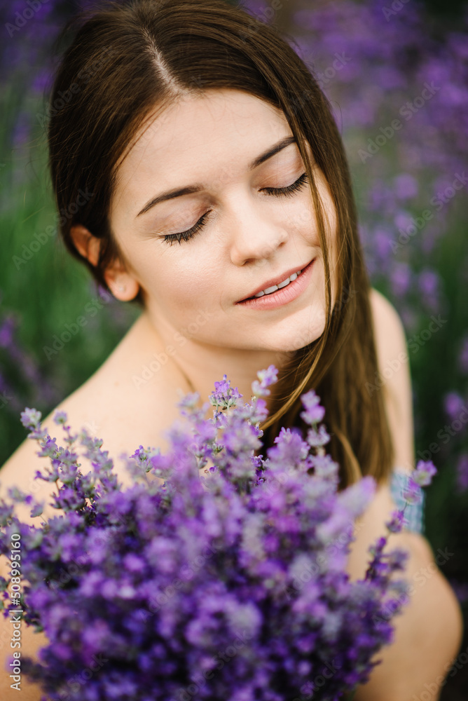 Girl sitting in a lavender flowers field. A woman walk on lavender field. Enjoy the floral glade, summer nature. Natural cosmetics concept. Female hold bouquet flowers and collect lavender. Closeup. Girl sitting in a lavender flowers field. A woman walk on lavender field. Enjoy the floral glade, summer nature. Natural cosmetics concept. Female hold bouquet flowers and collect lavender. Closeup.