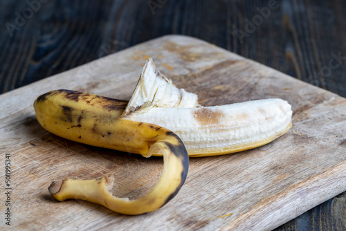 Quadro em tela old blackening banana on a cutting board, perishable banana fruit food