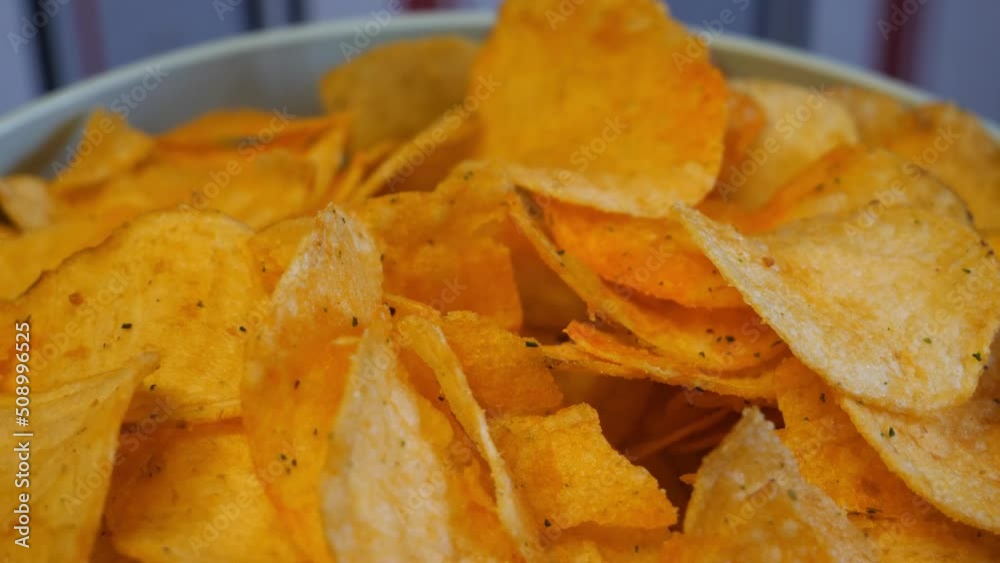 A full bowl of potato chips in close-up. 4k macro video.