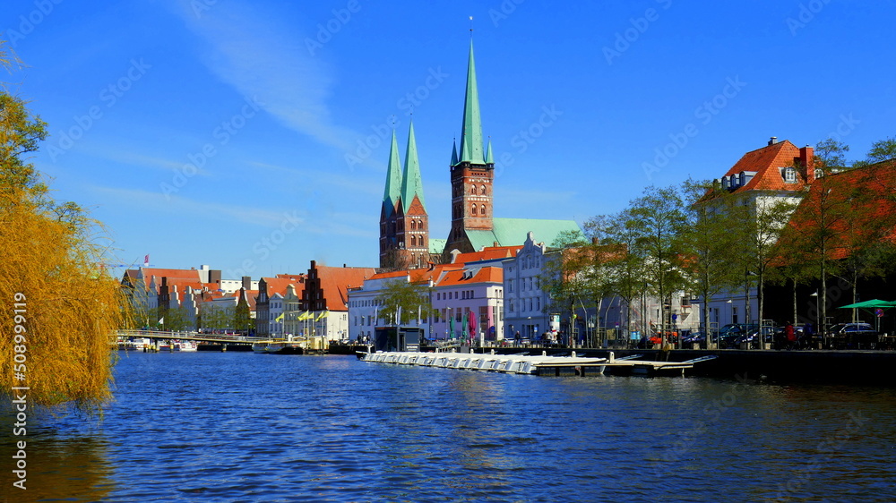 malerische historische Häuser entlang der Trave in Lübeck  und Türme von St. Petri und St. Marien