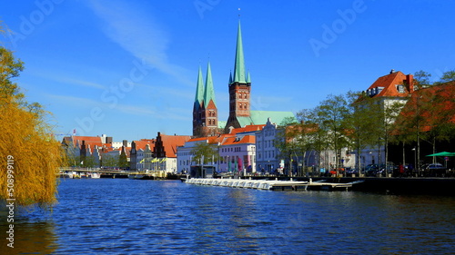 malerische historische Häuser entlang der Trave in Lübeck und Türme von St. Petri und St. Marien