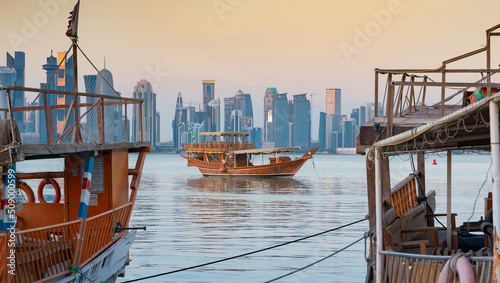 Traditional Arabic Dhow boats along with Doha skyline. photo