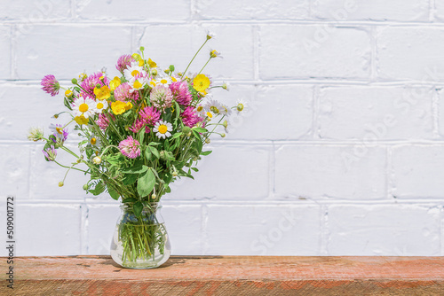 Decor from a bouquet of wild flowers on a white wall background