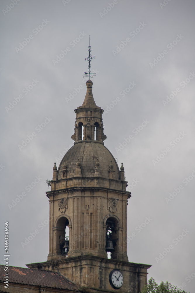 church dome in northern spain with clock in front with cloudy sky on spring day