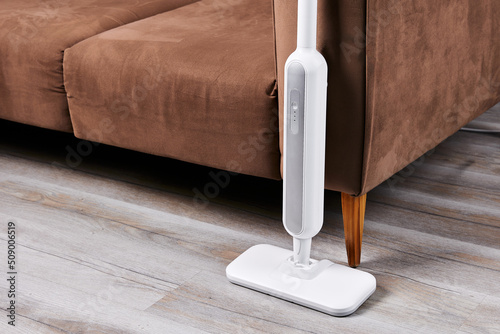 Electric mop to wash floor near sofa in living room closeup