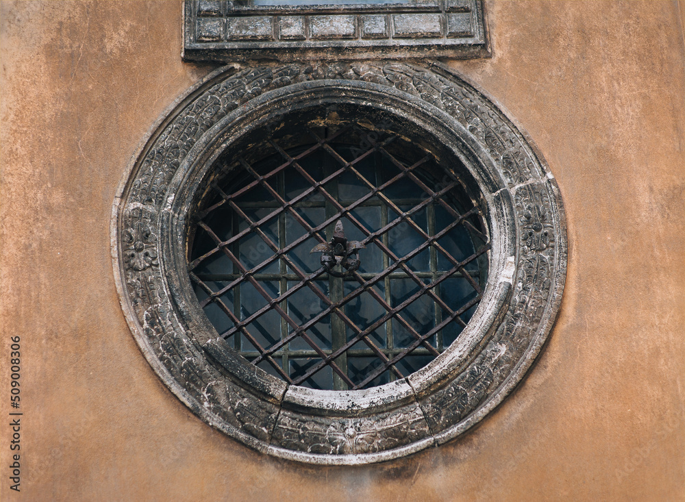 Large vintage round window with bars on the Boim Chapel in Lviv, Ukraine. Decorative element of an old renaissance building.