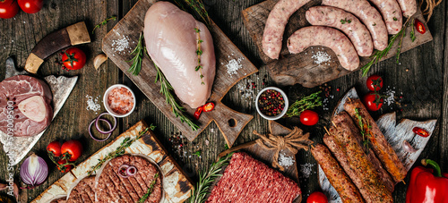 Raw meat products, different parts of the body. minced beef meat kebabs, pork, beef, chicken on a wooden background. Long banner format. top view