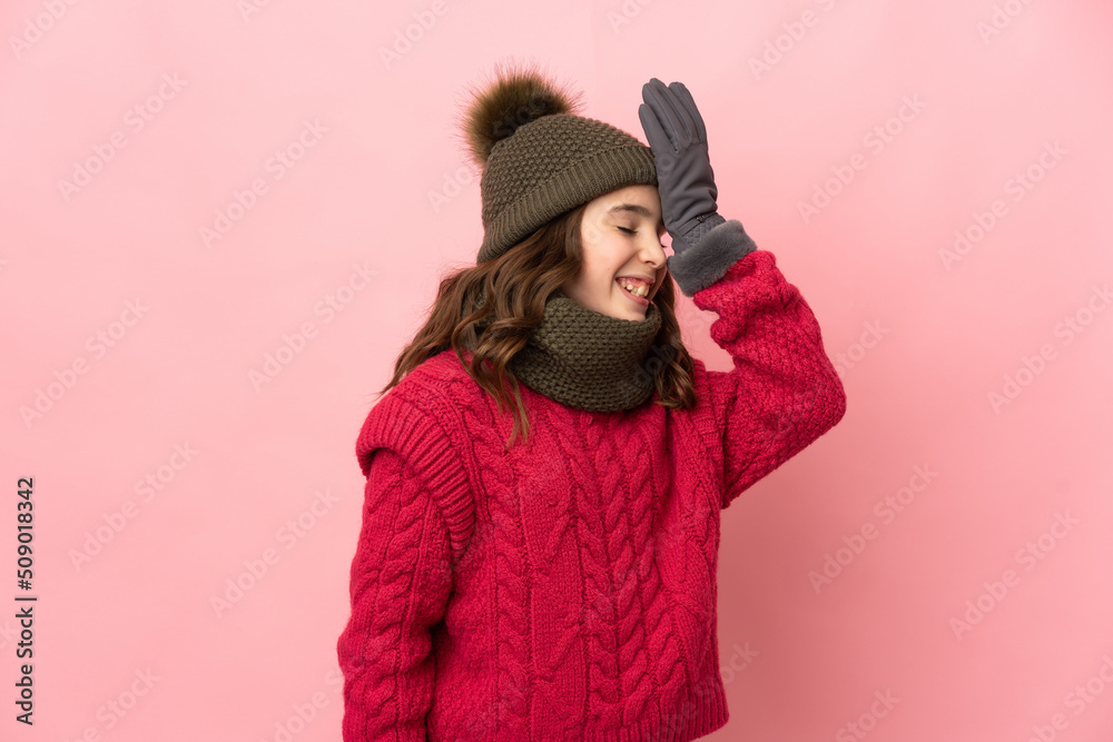 Little girl with winter hat isolated on pink background has realized something and intending the solution
