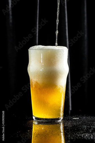 Wallpaper Mural glass of beer on dark background. beer being poured into glass Torontodigital.ca